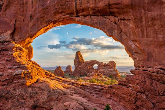 Golden rock formations at Arches National Park offer a breathtaking view during sunset hours.