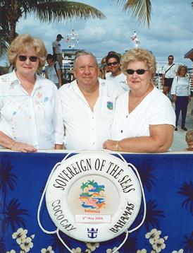 Three friends pose together at a cruise port in the Bahamas, enjoying the beautiful weather.