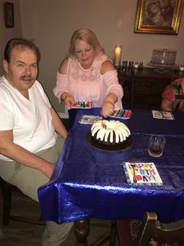 A joyful gathering takes place as family members enjoy cake and play games at their home.