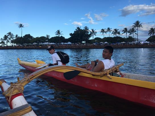 Two individuals in kayaks enjoy a leisurely paddle in a calm lagoon surrounded by palm trees.