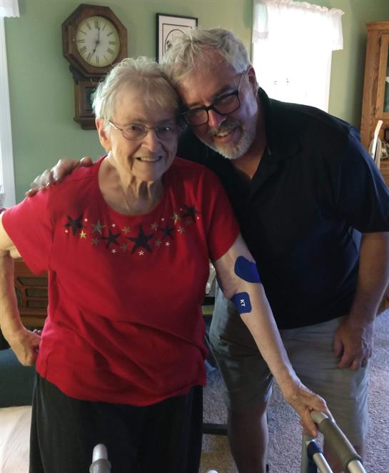 Grandmother and grandson joyfully embrace in a cozy living room, celebrating family.