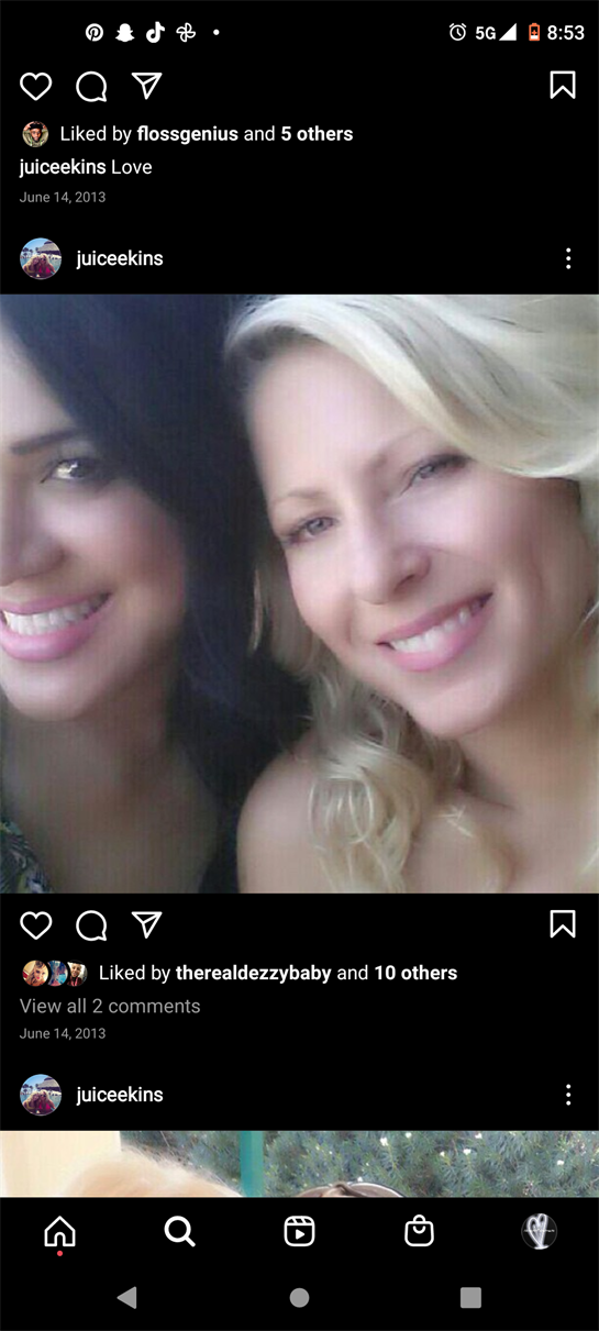 Two friends laugh and enjoy each other's company on a sunny day outdoors.