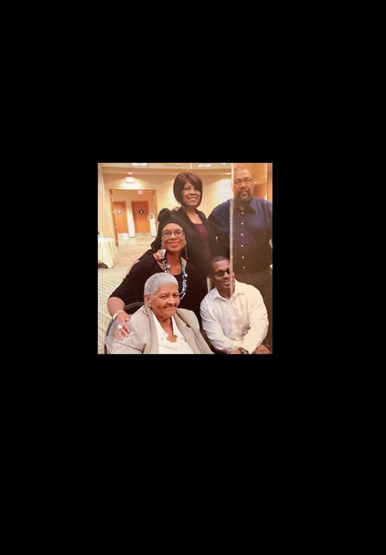 Five family members are happily posing together during a celebration in a cozy environment.