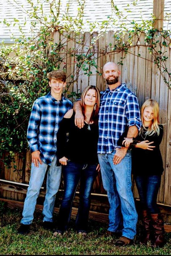 A joyful family gathers in a garden, showcasing their well-coordinated casual outfits in plaid.