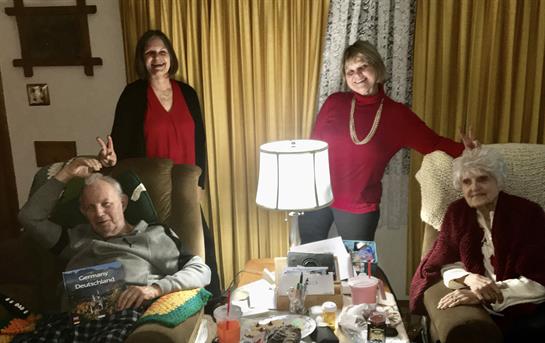 Friends and family enjoy a lively evening together in a warmly lit living room, sharing smiles.