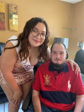 Two friends share a joyful moment in a cozy setting, showcasing their stylish outfits and smiles.