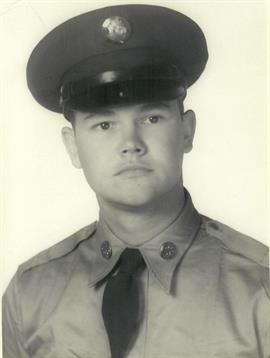 A young man poses in a military uniform, displaying serious expression, circa mid-20th century.
