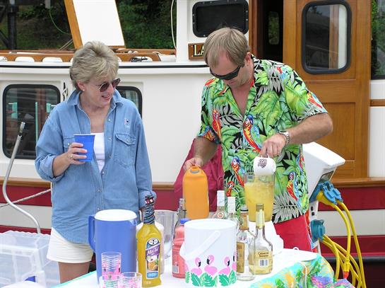 Friends prepare colorful tropical drinks while enjoying a relaxed afternoon on a boat.