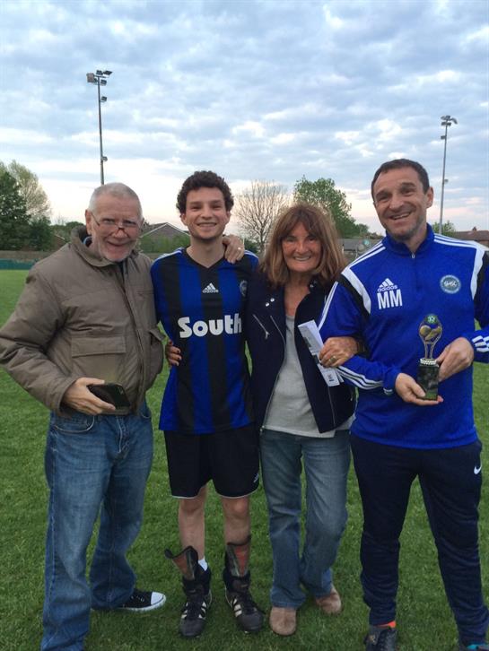 Family gathers on the soccer field to honor a young player's accomplishment after the match.