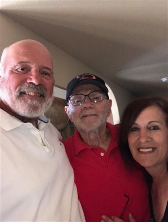 Three family members pose together, showcasing their happiness and connection in a warm environment.