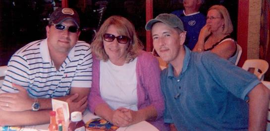 Three friends relax at a restaurant with sunglasses on, sharing a lighthearted moment together.