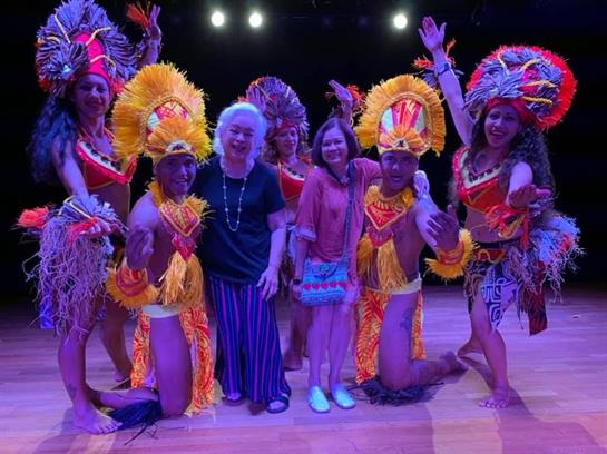 Traditional dancers in colorful attire engage an audience during a lively cultural festival.