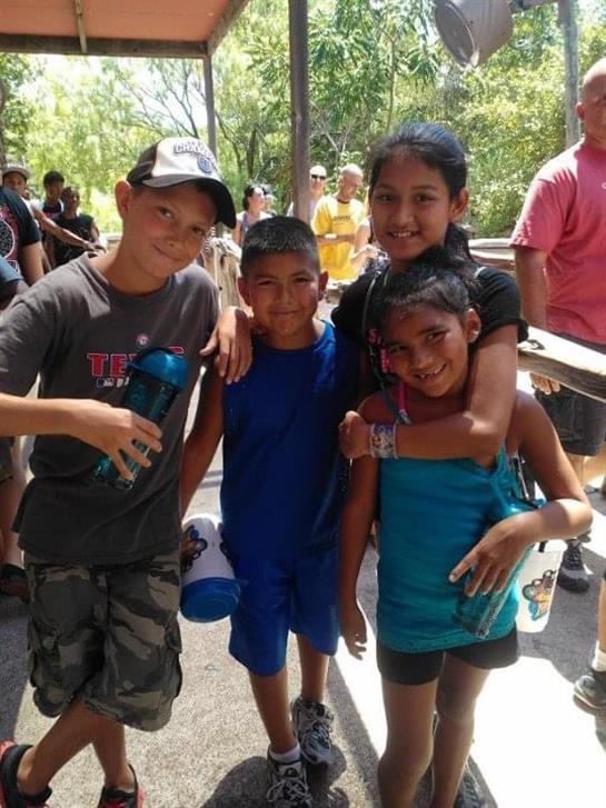 Kids enjoy their time together outdoors, laughing and playing in the warm sun at a park event.