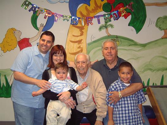 Family gathers joyfully to celebrate a birthday in a festive, decorated space.