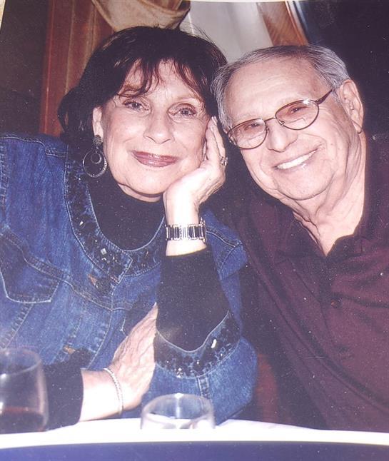 Two people share a warm smile while sitting at a table, enjoying their time together at dinner.