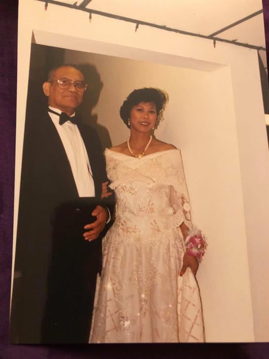 Couple in elegant attire exudes joy and sophistication at a formal event.