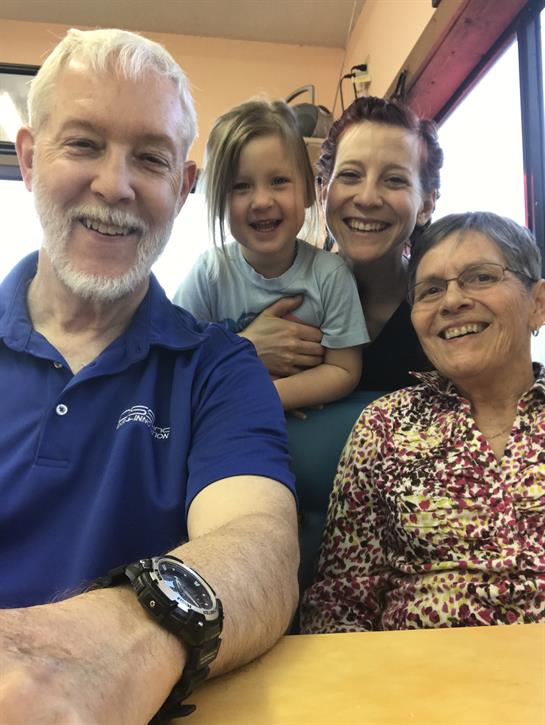 A joyful family gathers at a restaurant, sharing smiles and laughter together.