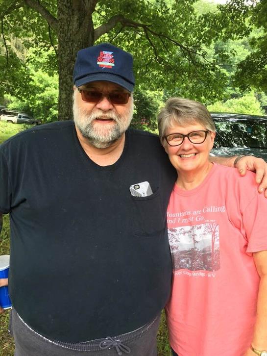 Two friends share a joyful moment outdoors during a summer gathering in the backyard.