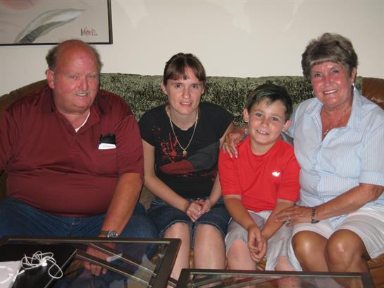 A joyful family poses together on a sofa, enjoying a moment of togetherness in their home.