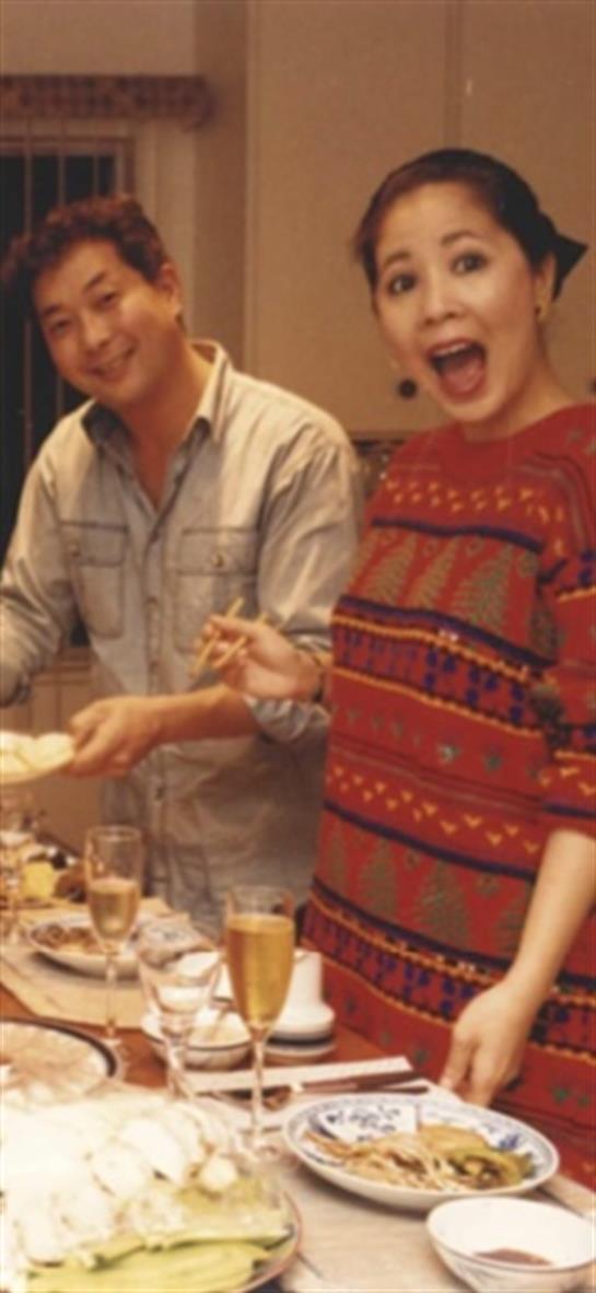 Two friends are joyfully participating in a winter gathering while sharing a meal and laughter.
