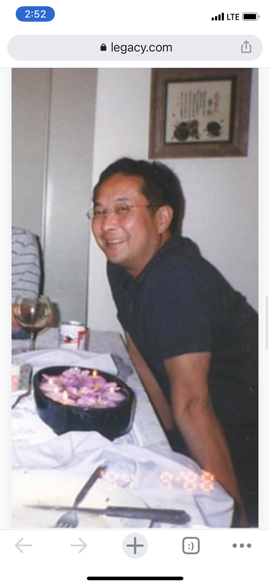 Man enjoys a relaxed evening at a dinner table adorned with flowers and drinks, exuding warmth.