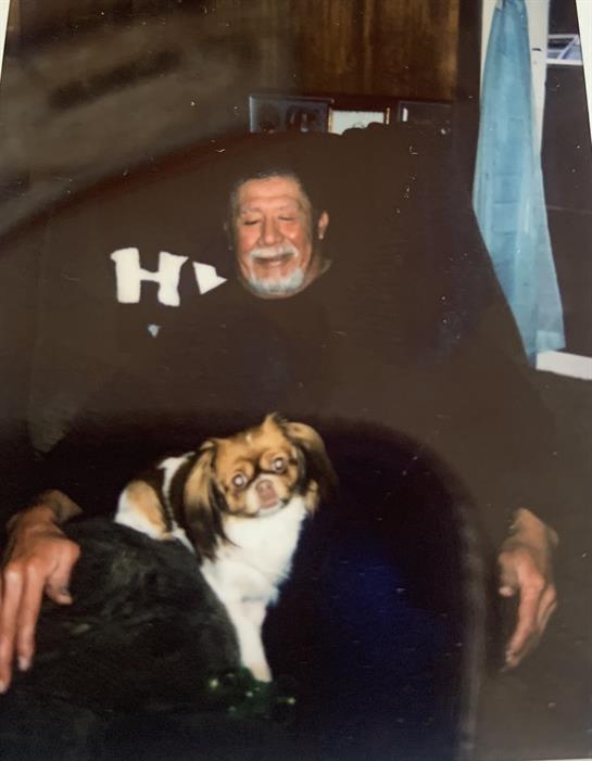 A man enjoys a peaceful moment with a small dog in a comfortable chair indoors.
