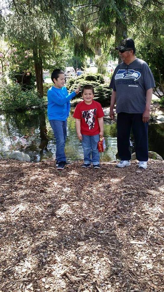 Family members gather by a pond, enjoying the serene environment and each other's company.