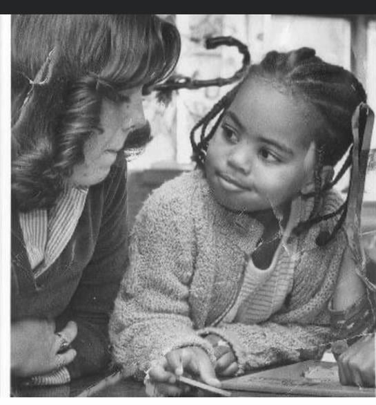 Two children focus on a creative task, sharing ideas and collaborating in a bright classroom.