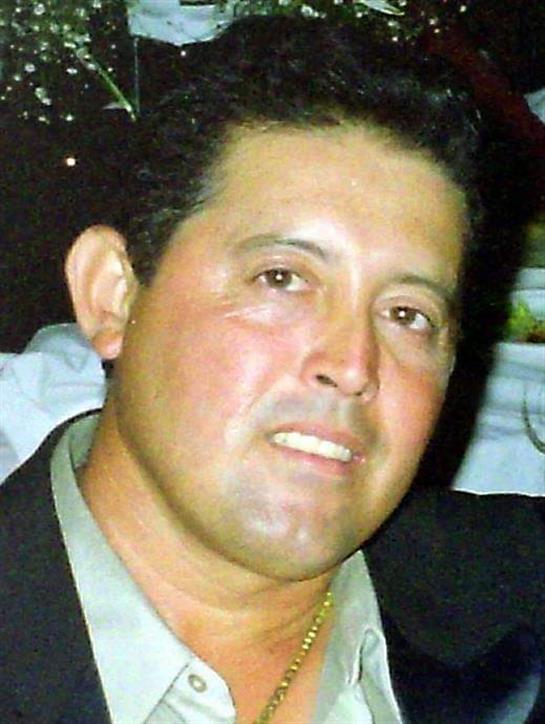 A man is enjoying a cheerful moment at a social event with friends, showcasing happiness.