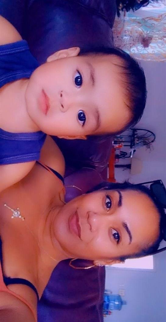 A mother and her young child enjoy a close and affectionate moment indoors.