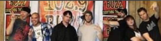 Two individuals stand side by side, smiling at a gathering with a vibrant decorative background.