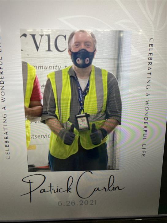Community event highlights a volunteer in a vest and mask, celebrating service.