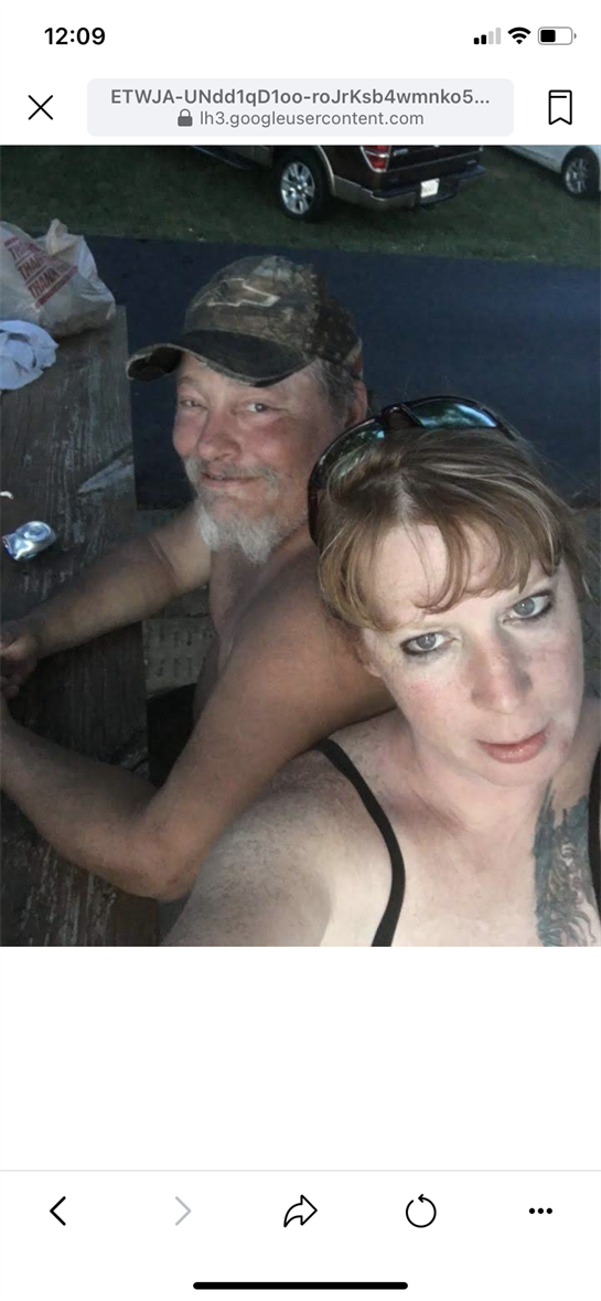 Two friends share a fun moment outdoors by the water on a warm summer evening.