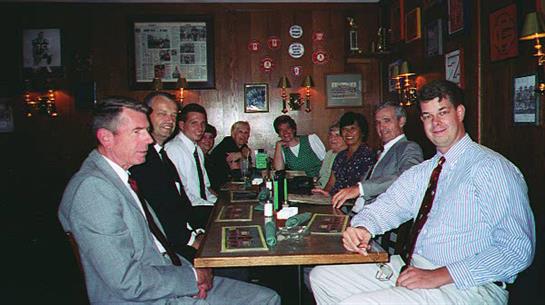 People sit around a table, chatting and enjoying their meal in a cozy atmosphere.