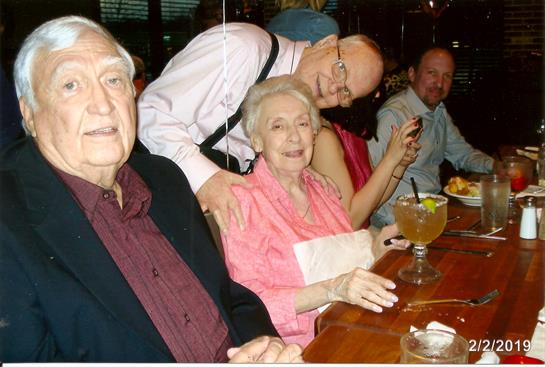 Friends gather around a table at a restaurant, sharing laughter and drinks during the evening.