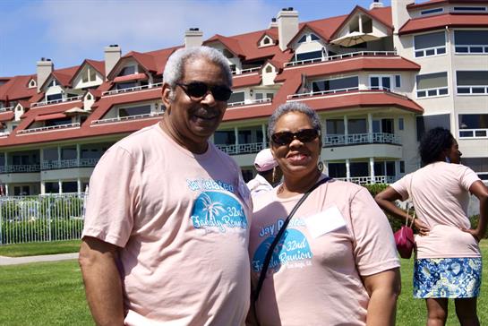 Happy couple poses together on a sunny day at a resort, enjoying their time outside.