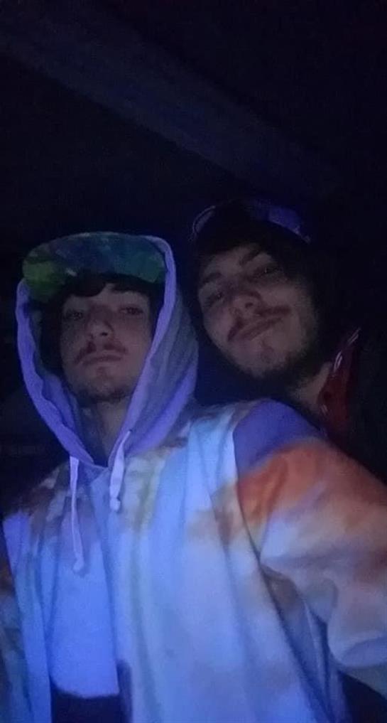 Friends enjoy a fun moment together, smiling and posing in low light during nighttime.