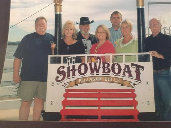 Friends gather for a joyful moment at Branson Belle, enjoying the scenic views and warm weather.