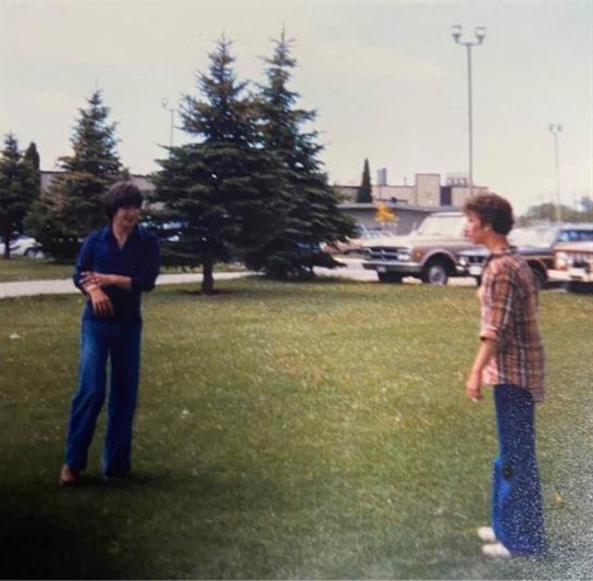 Friends enjoy a fun moment outdoors, laughing and interacting in a vibrant park setting.