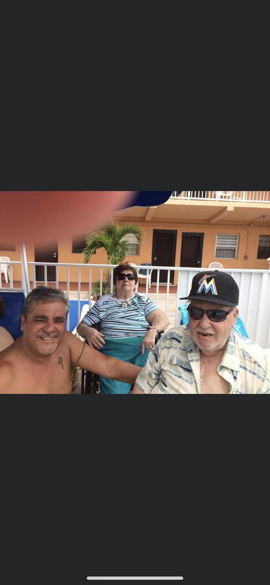 Three friends relax by the pool, sharing laughter and enjoying the sunny day.