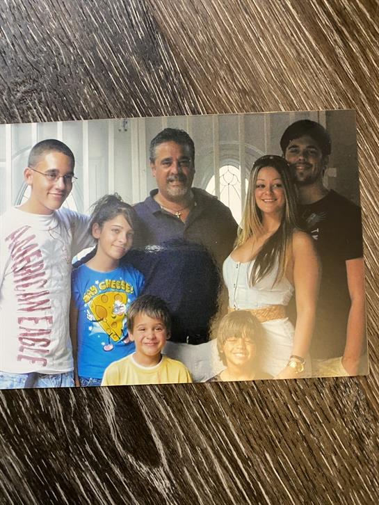 Family members smiling and enjoying each other's company in a cozy indoor setting.