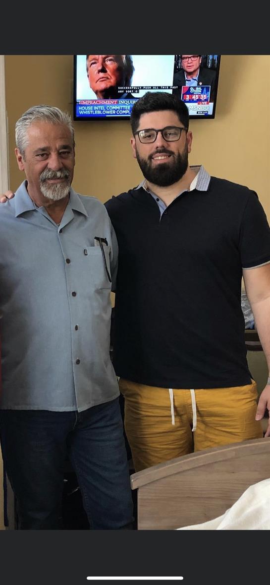 Two men pose for a picture, showing friendly expressions while enjoying their time together.