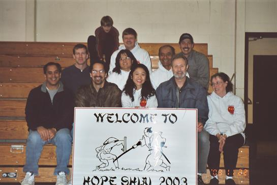 A gathering of diverse individuals smiling together in a community gym during the Hope Show event.