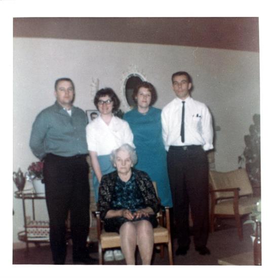 Five relatives pose together in a comfortable living room, showcasing their warmth and connection.