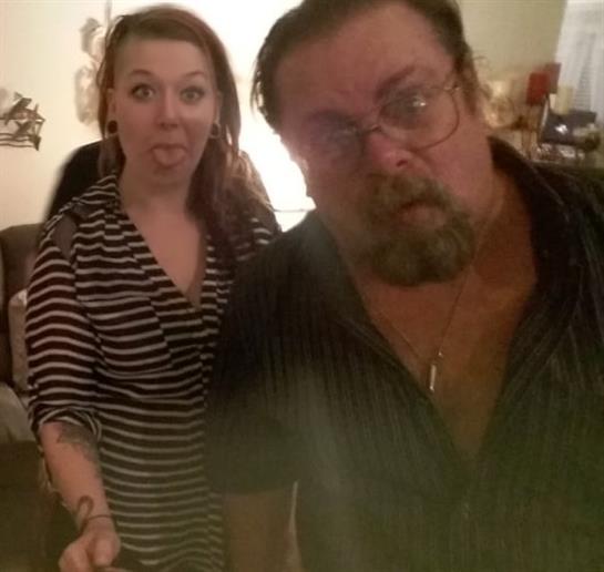 Two friends with playful expressions are posing for a selfie at a relaxed gathering.