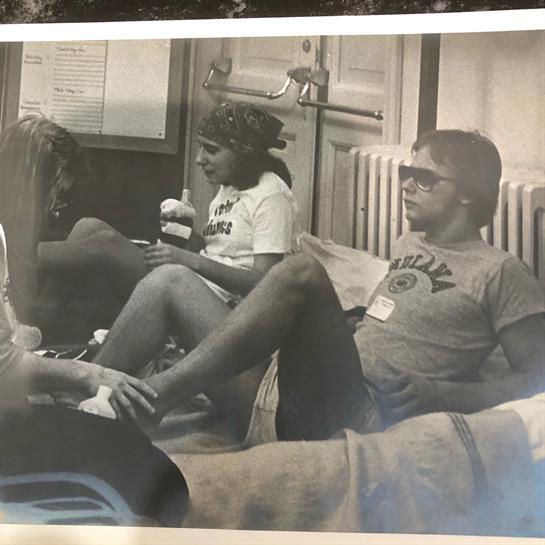 Friends laugh and share snacks indoors, enjoying each other's company in a relaxed vibe.