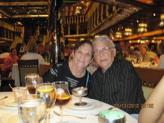 Elderly couple shares a joyful moment at a beautifully set table during dinner.