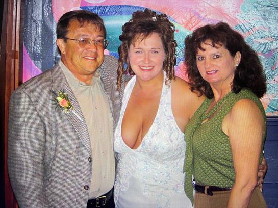 Three friends pose happily at a lively event, showcasing their vibrant outfits and smiles.