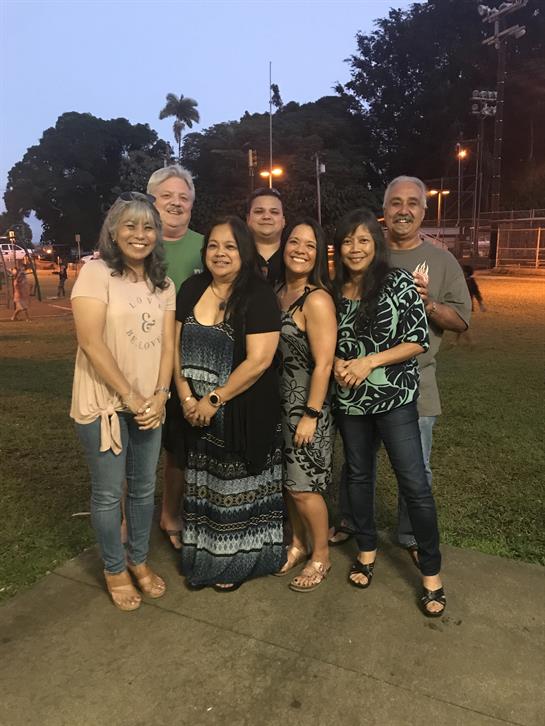 Friends pose together for a cheerful gathering in the park, enjoying the evening atmosphere.