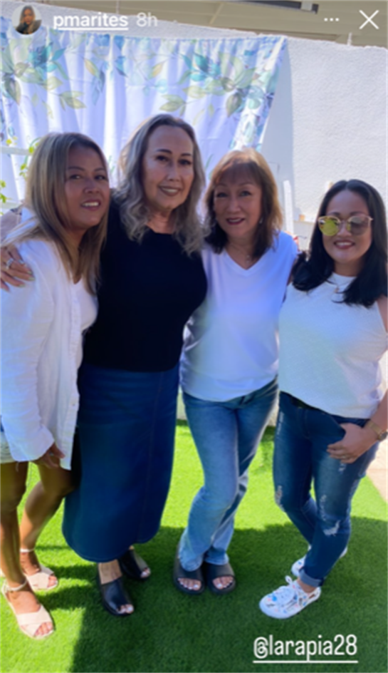 Four friends enjoy a joyful moment together in a vibrant outdoor space under the sun.